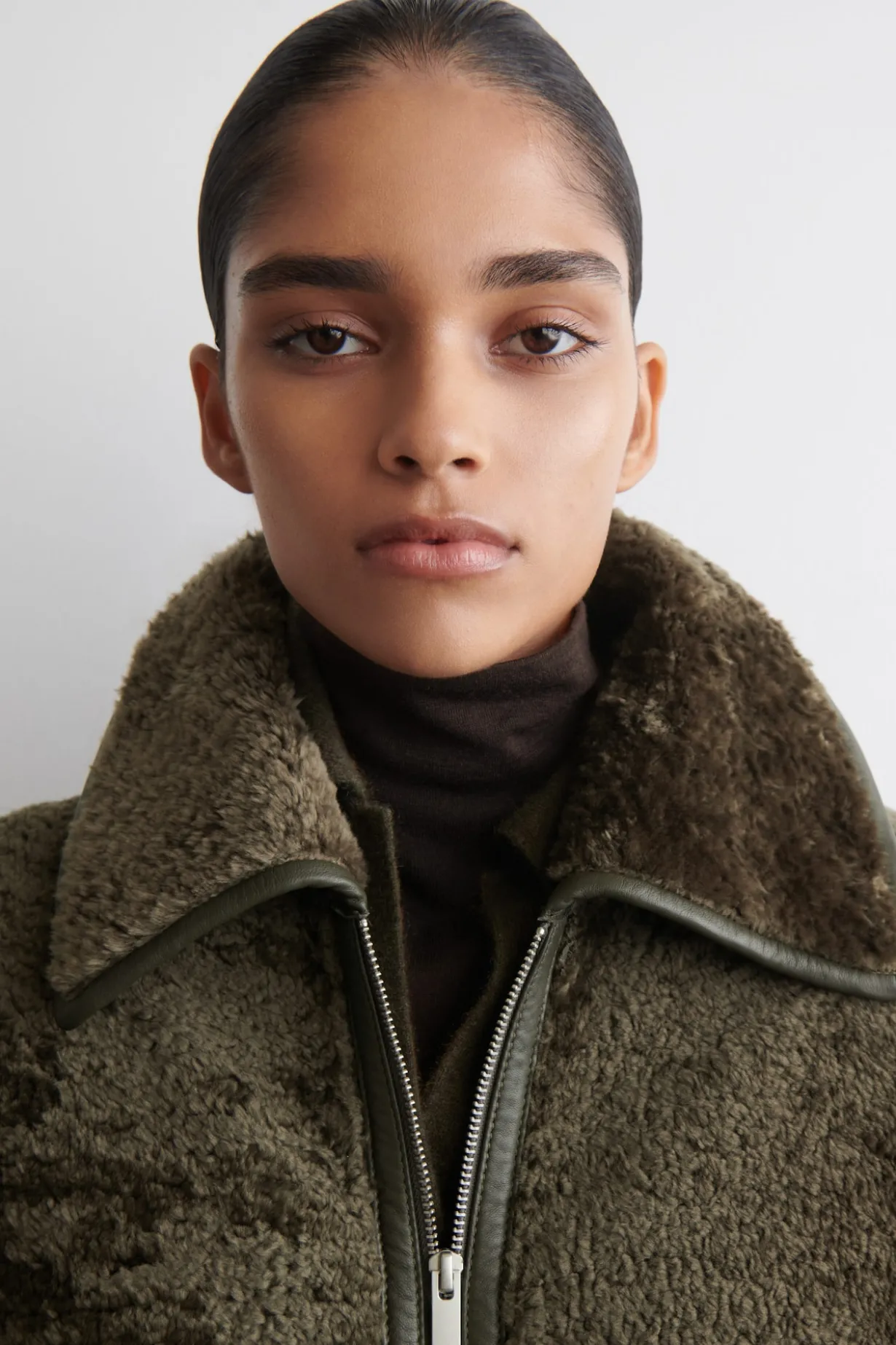 LANGER MANTEL AUS SHEARLING MIT LEDERDETAILS